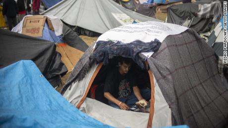 A Central American migrant eats inside a tent at a temporary shelter in Tijuana on November 29, 2018.