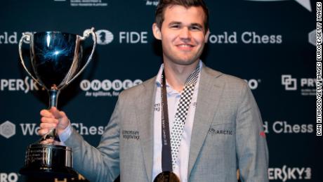 Carlsen își deține trofeul după ce l-a învins pe Fabiano Caruana pentru a-și recăpăta titlul de campion mondial de șah pe 28 noiembrie 2018 la Londra.
