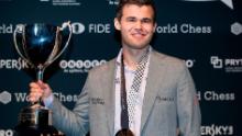 Carlsen își deține trofeul după ce l-a învins pe Fabiano Caruana pentru a-și recăpăta titlul de campion mondial de șah pe 28 noiembrie 2018 la Londra.