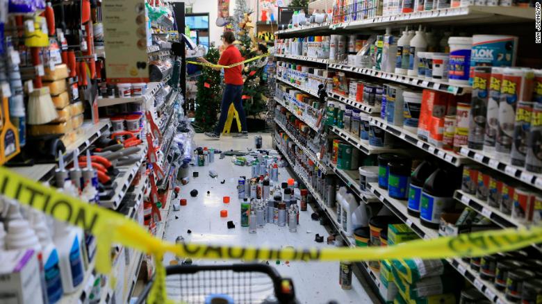 An employee walks past a damaged aisle in an Anchorage store after the earthquake. 
