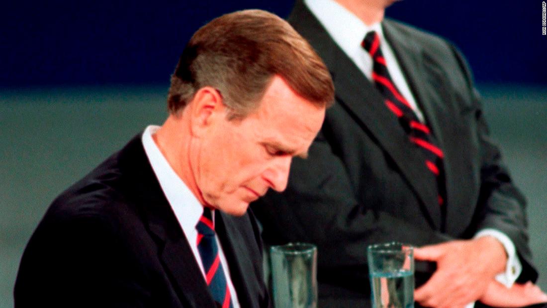 Bush checks his watch during a 1992 presidential debate with Ross Perot, right, and Bill Clinton. The memorable moment was interpreted as the President being out of touch.