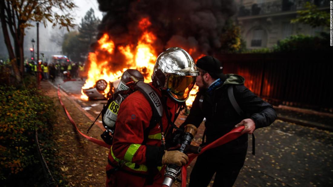 Firemen work to extinguish a burning car on December 1.