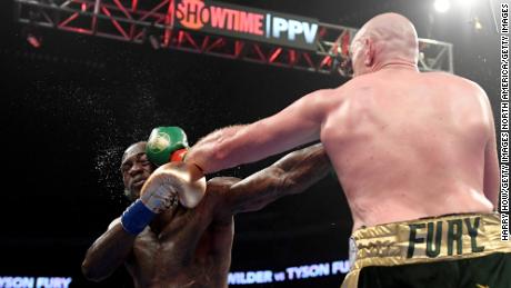 Tyson Fury punches Deontay Wilder in the fifth round.