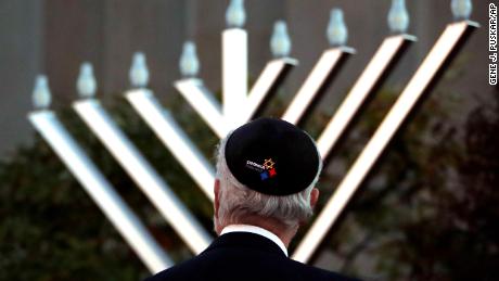 Rabbi Jeffrey Myers watches the installation of a menorah outside the Tree of Life Synagogue before a Hanukkah ceremony Sunday evening. 