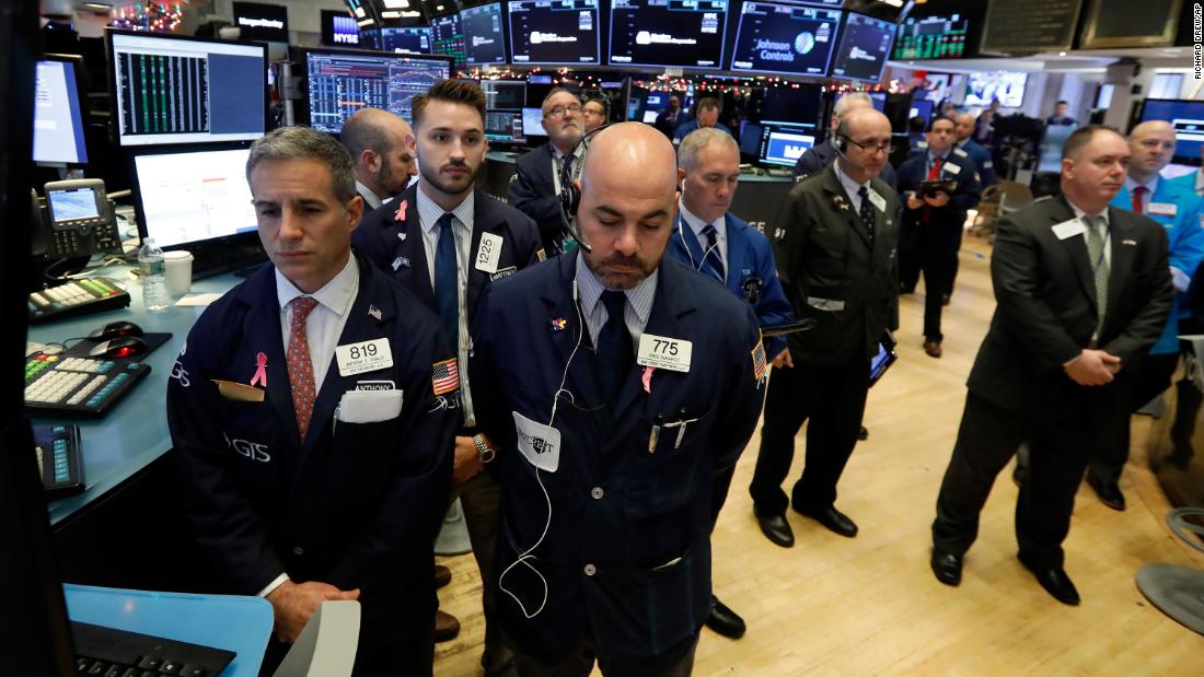 Traders on the floor of the New York Stock Exchange pause for a moment of silence on December 3.