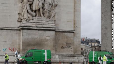 Workers clean grafitti off the Arc de Triomphe.