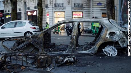 A burned-out car sits in a Paris street the day after riots spread through the city.