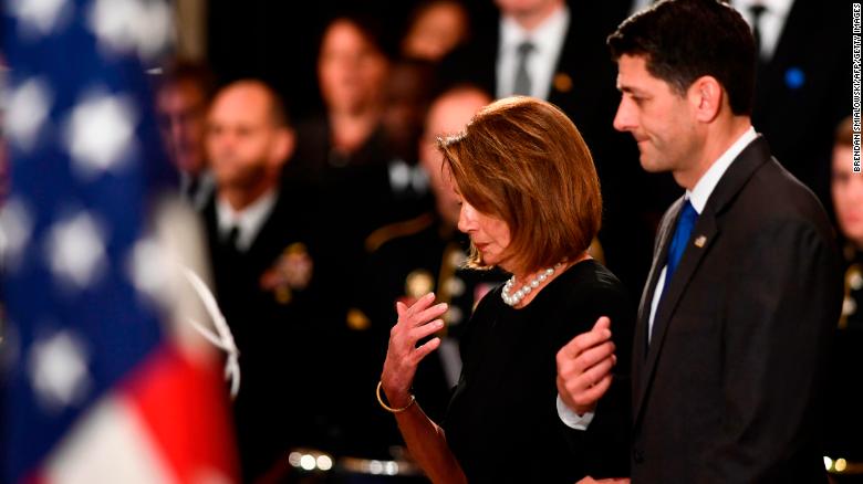 House Democratic Leader Nancy Pelosi and speaker of the US House of Representatives Paul Ryan pay their respects to former US President George H.W. Bush at the US Capitol during a ceremony in Washington, DC. (Photo by Brendan Smialowski / AFP)    