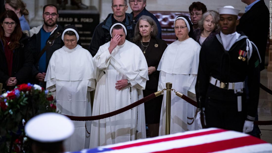 Members of the public pay their respects to the late President on December 3.