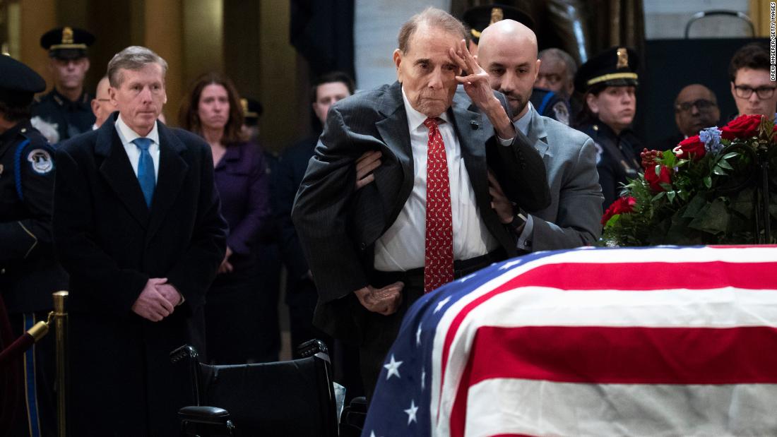 Former US Sen. Bob Dole salutes Bush&#39;s casket as he is helped out of his wheelchair on Tuesday, December 4. Bush was lying in state at the Capitol rotunda.