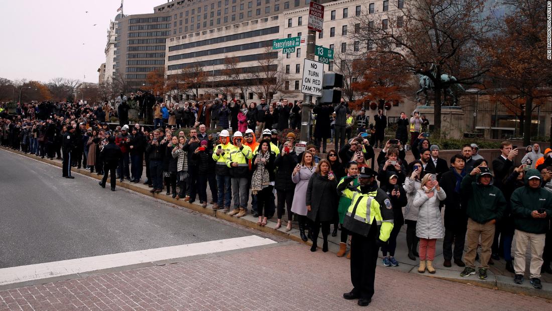 People watch as Bush&#39;s hearse passes Freedom Plaza in Washington on the way to the funeral.