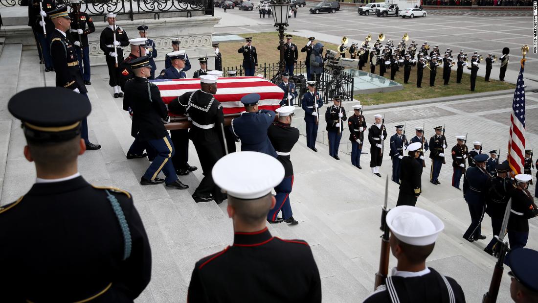A military honor guard carries Bush&#39;s casket down the steps of the US Capitol. 