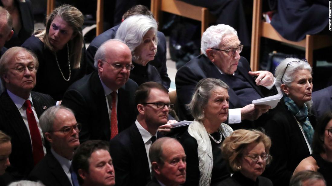 Former Secretary of State Henry Kissinger, top right, sits near former White House Chief of Staff Karl Rove at the funeral.