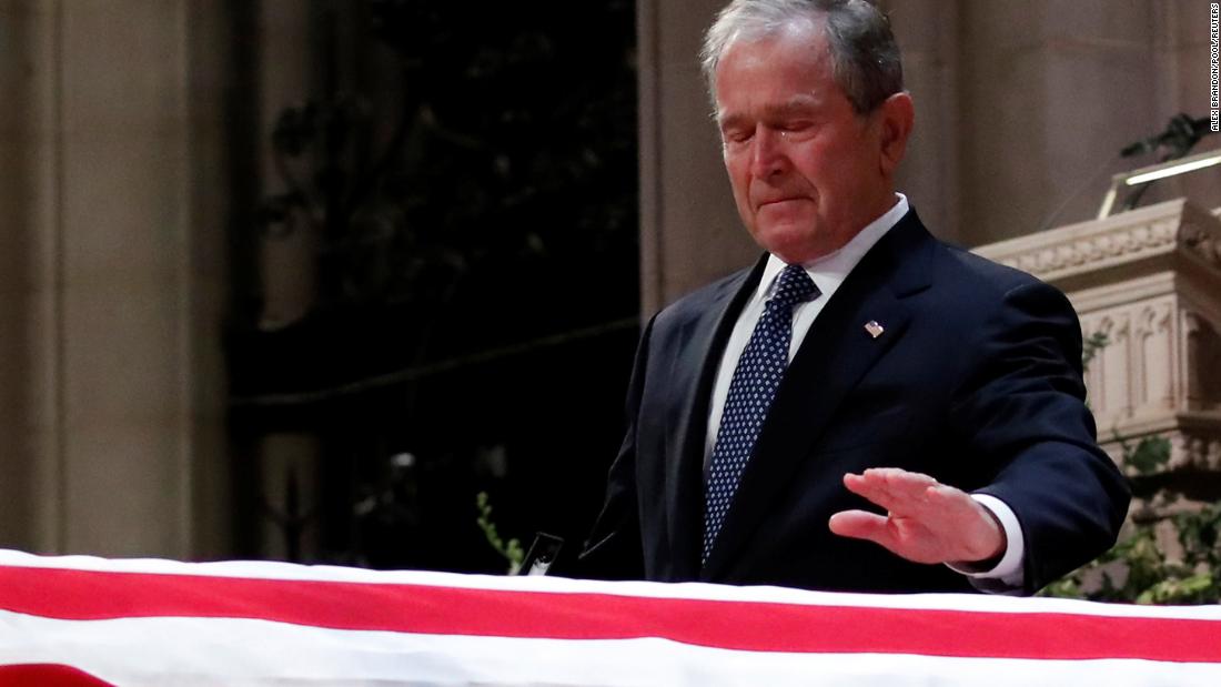 George W. Bush touches his father&#39;s casket.