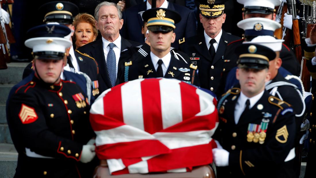 Former President George W. Bush trails a military honor guard carrying his father&#39;s casket after a state funeral in Washington on December 5.