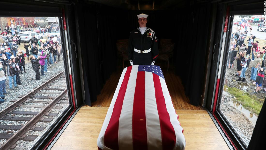 Navy guard Kenneth Knox stands over the flag-draped casket of the late President as a train carries it to his presidential library at Texas A&amp;amp;M University.