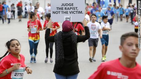 A women's rights protester holds a #ShameOnWho campaign banner at Beirut's yearly marathon this November. 