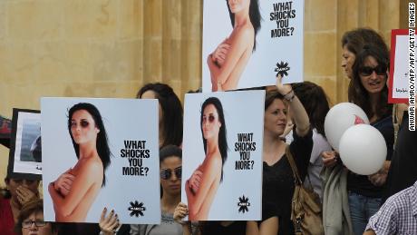 Women hold placards denouncing domestic violence during a rally on the "International Women's Day" on March 8, 2014 in front of the National Museum in the capital Beirut. 