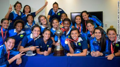 Colombia's Atletico Huila Femenino players pose with the Copa Libertadores trophy at a press conference in Bogota.