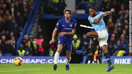 Raheem Sterling of Manchester City shoots as Marcos Alonso of Chelsea looks on during the Premier League match between Chelsea and Manchester City on Saturday.