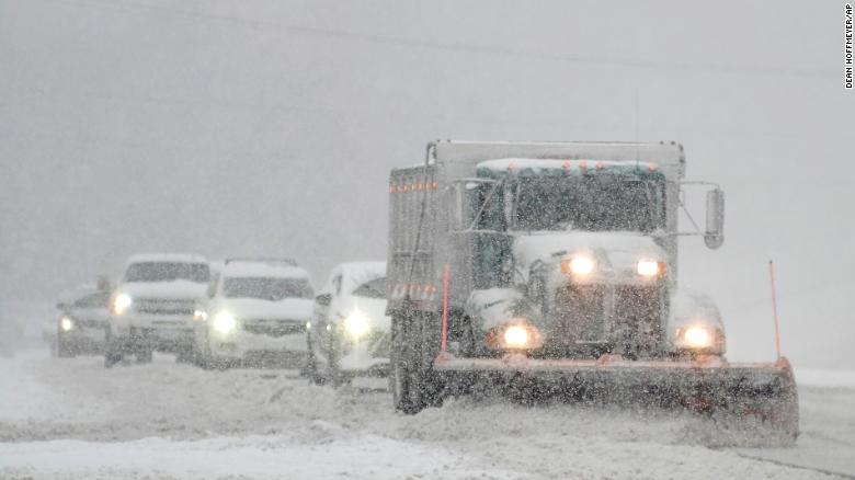 A snowplow is followed closely by cars as it clears US 301 in Hanover County, Virginia, on Sunday.