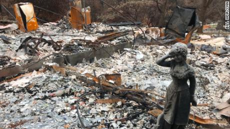 A statue stands amid the ruins of a home destroyed by the Camp Fire in Paradise, California.