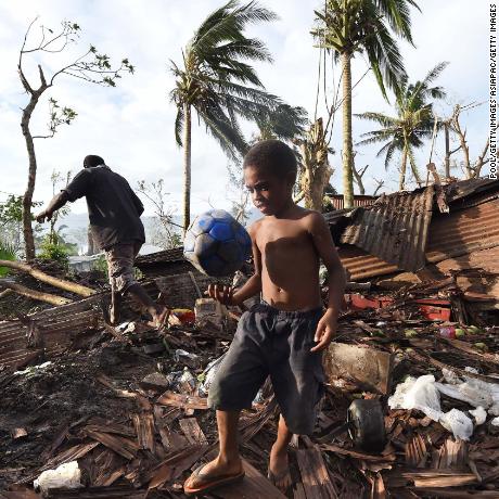 PORT VILA, VANUATU - MARCH 16:  Samuel walk through through the ruins of his family home with his father Phillip, on March 16, 2015 in Port Vila, Vanuatu. Cyclone Pam has hit South Pacific islands on Saturday with hurricane force winds, huge ocean swells and flash flooding and has caused severe damage to housing. Aid agencies say it could be one of the worst disasters ever to hit the region.  (Photo by Dave Hunt-Pool/Getty Images)