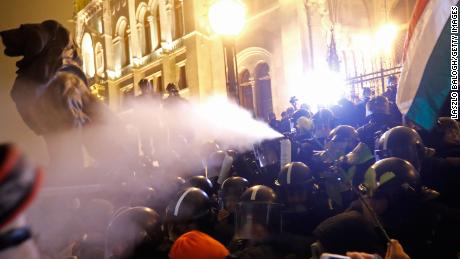 Riot police spray tear gas at demonstrators outside parliament on Thursday night. 