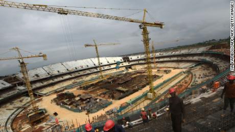 This picture taken on July 24, 2018 shows workers on a construction site of the new olympic stadium in Ebimpe, ahead of the African Cup of Nations (CAN) 2021.