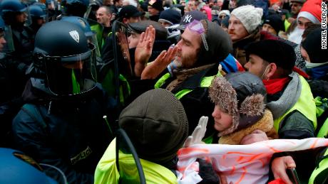 "Yellow vest" demonstrators face riot police officers Saturday in the French capital. 