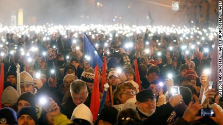 Demonstrators  stand outside Hungary&#39;s Parliament on Sunday in Budapest.