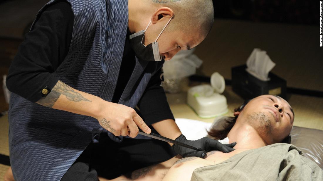 Artist Horimyo tattooing the shoulder of calligrapher Hayato Suzuki in Tokyo.