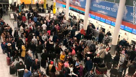 Lines of passengers wait at the check-in desks at Gatwick Airport.