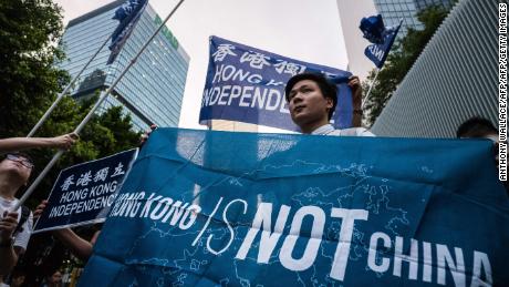 Activists hold flags which read "Hong Kong Independence" and "Hong Kong Is Not China" during a gathering outside the government headquarters to mark the fourth anniversary of mass pro-democracy rallies, known as the Umbrella Movement, in Hong Kong on September 28, 2018.