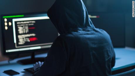 cybercrime, hacking and technology concept - male hacker in dark room writing code or using computer virus program for cyber attack; Shutterstock ID 1083511010; Job: -