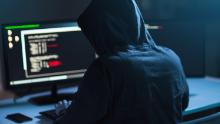 cybercrime, hacking and technology concept - male hacker in dark room writing code or using computer virus program for cyber attack; Shutterstock ID 1083511010; Job: -