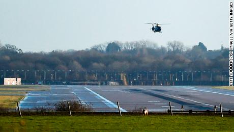 A police helicopter flies over the runway at Gatwick airport.