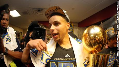 Stephen Curry of the Golden State Warriors celebrates with the Larry O&#39;Brien NBA Championship Trophy after he and the Golden State Warriors defeated the Cleveland Cavaliers in Game Six of the 2015 NBA Finals.
