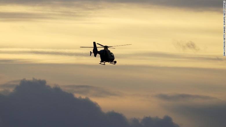 A police helicopter flies over London&#39;s Gatwick Airport as officers search for a drone operator who caused closure of the airport on Thursday.