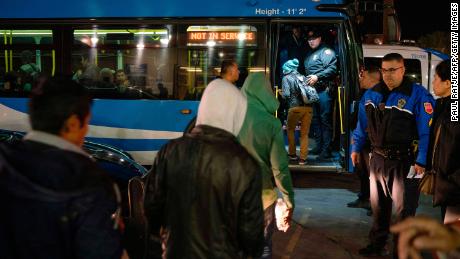 Asylum seekers board a bus stop after they were dropped off by Immigration and Customs Enforcement (ICE) officials earlier at the Greyhound bus station in downtown El Paso, Texas late on December 23, 2018. 