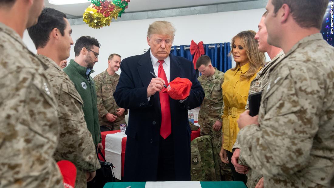 President Trump signs &quot;Make America Great Again&quot; hats for US troops during his surprise visit.