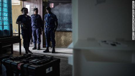 Congolese policemen guard voting machines in a school where the voting material is stocked in Kinshasa's Victoire district.