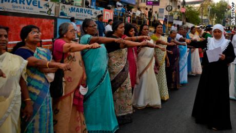 Women raise their hands to take a pledge to fight gender discrimination as they form part of a hundreds kilometer long &quot;women&#39;s wall&quot; in Thiruvananthapuram, in the southern Indian state of Kerala, Tuesday, Jan. 1, 2019. The wall was organized in the backdrop of conservative protestors blocking the entry of women of menstruating age at the Sabarimala temple, one of the world&#39;s largest Hindu pilgrimage sites defying a recent ruling from India&#39;s top court to let them enter. (AP Photo/R.S. Iyer)