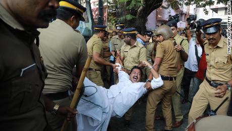 Police carry away a protester in Kochi, Kerala, after two women successfully entered a shrine they were previously barred from visiting. 