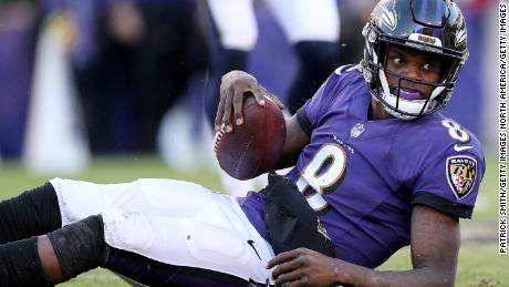 Lamar Jackson of the Baltimore Ravens looks on from the ground after being tackled.