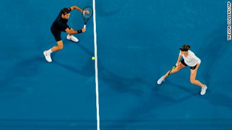 Switzerland's Roger Federer plays a shot, watched by teammate Belinda Bencic during their mixed doubles match against Alexander Zverev and Angelique Kerber of Germany.