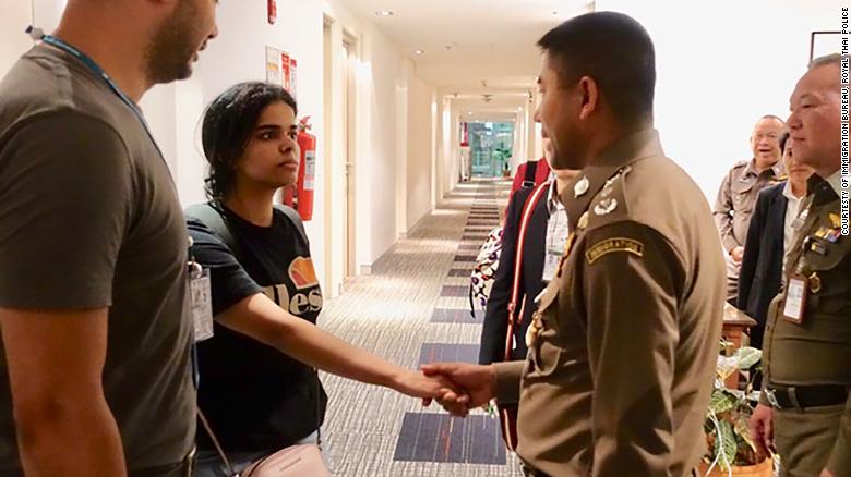 Rahaf al-Qunun, 18, shakes hands with a Thai official after she is escorted out of the Bangkok airport hotel room where she had barricaded herself in. 