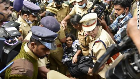 Indian police protect a female Hindu devotee after her entry to Sabarimala temple was blocked by hardline activists, December 24, 2018. 