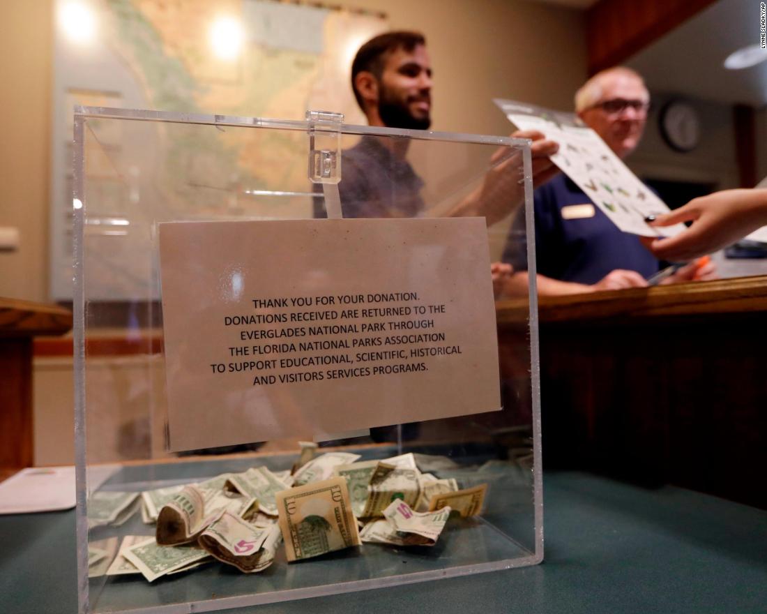 A donation box sits on the counter at the Ernest F. Coe Visitor Center in Florida&#39;s Everglades National Park. Dany Garcia, center, was being paid by the Florida National Parks Association to work in the center during the partial government shutdown.