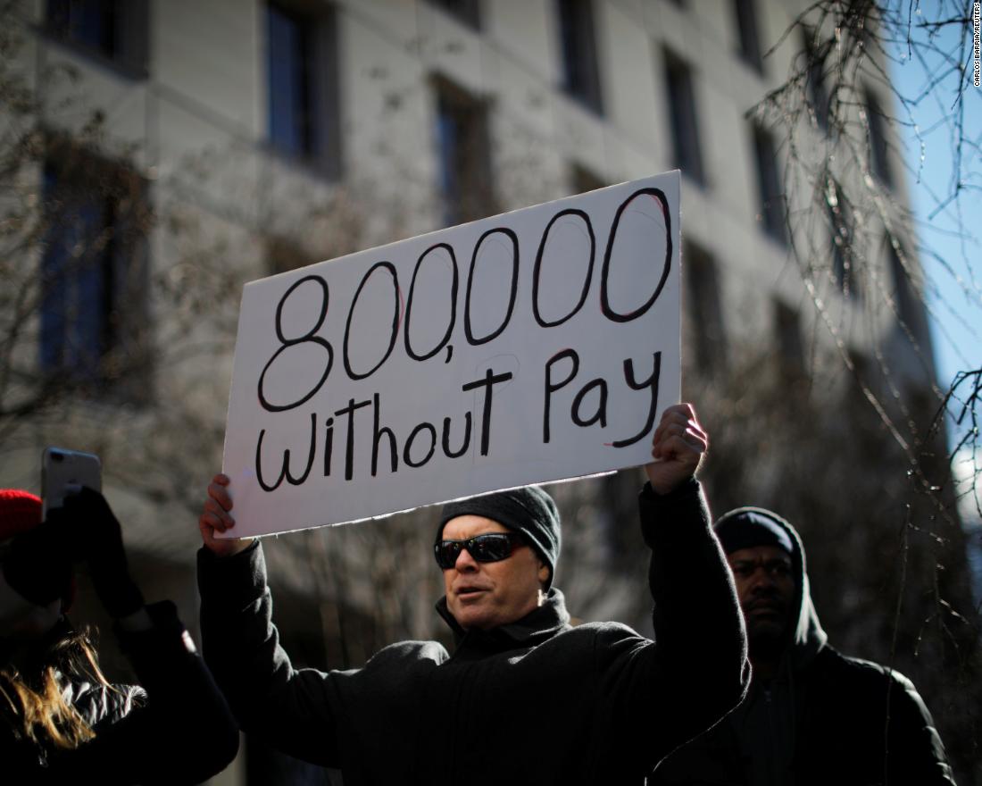 A protester holds a sign during a rally in Washington on January 10. Around 800,000 federal workers were out of work or were working without pay because of the shutdown. 